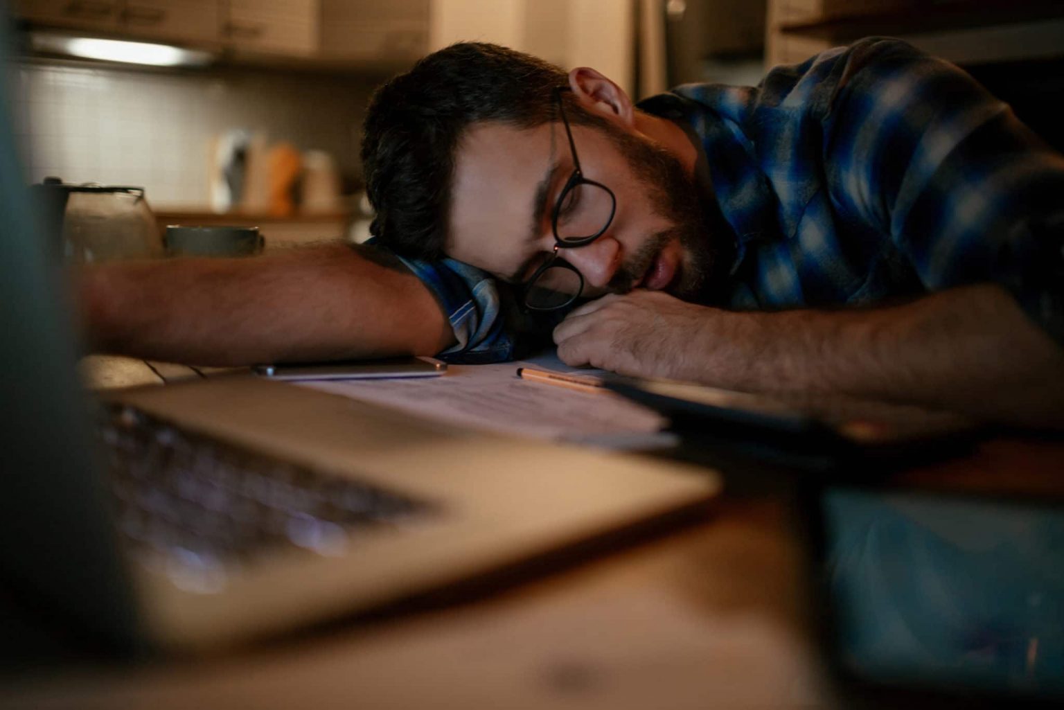 A man asleep at desk experiencing narcolepsy.