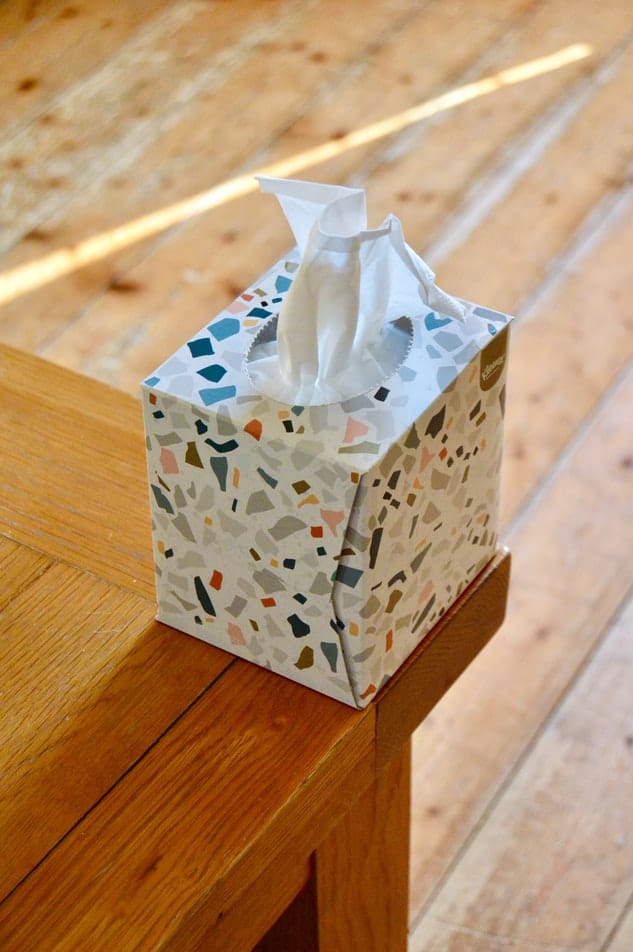 A box of tissues on a wooden counter.